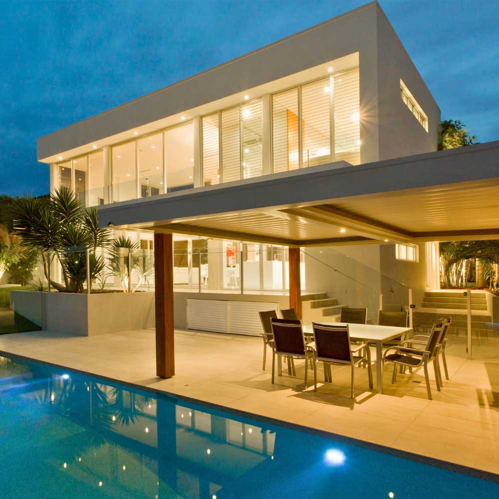 luxury home at dusk with patio lights on